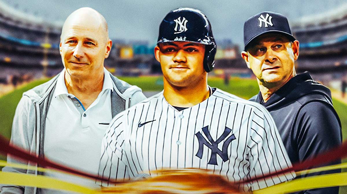 New York Yankees outfielder Jasson Dominguez in center, New York Yankees general manager Brian Cashman on left side, New York Yankees manager Aaron Boone on right side, Yankee Stadium (home stadium of the New York Yankees) in background