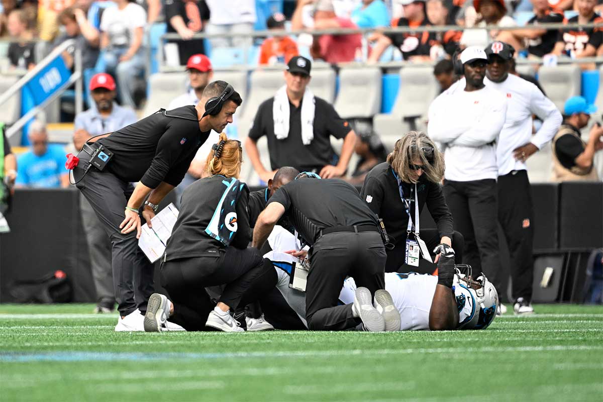 Panthers head coach Dave Canales checks on linebacker Shaq Thompson (54) after an injury in the third quarter at Bank of America Stadium