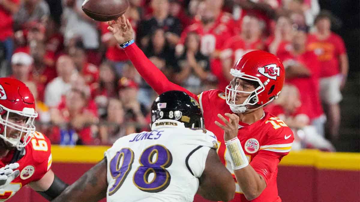 Kansas City Chiefs quarterback Patrick Mahomes (15) throws a pass as Baltimore Ravens defensive tackle Travis Jones (98) defends during the first half at GEHA Field at Arrowhead Stadium.