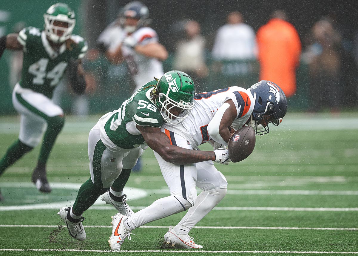 Denver Broncos running back Tyler Badie (28) fumbles after being hit by New York Jets linebacker Quincy Williams (56) during the first half at MetLife Stadium.