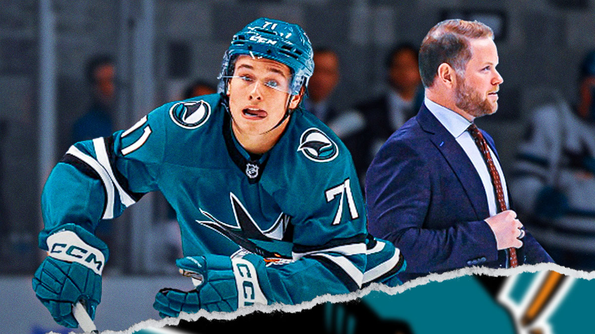 Macklin Celebrini looking stern, Ryan Warsofsky also in image, San Jose Sharks logo, hockey rink in background