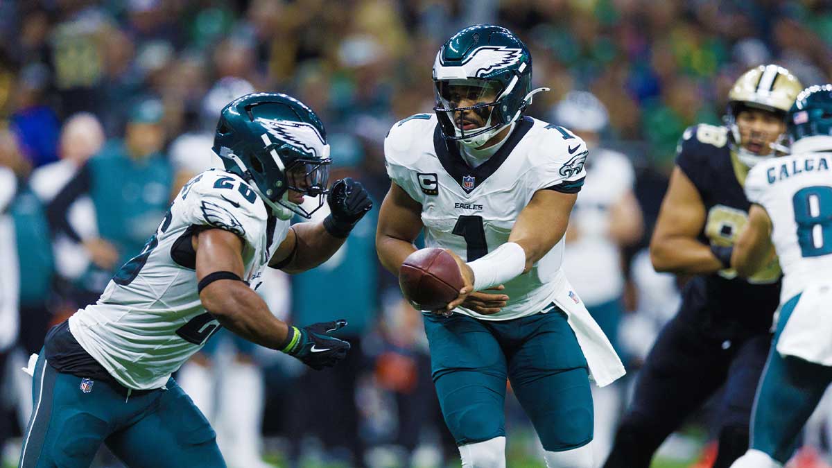 Philadelphia Eagles quarterback Jalen Hurts (1) hands off to running back Saquon Barkley (26) against the New Orleans Saints during the second half at Caesars Superdome.