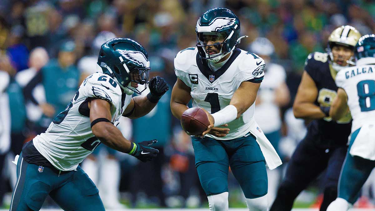 Philadelphia Eagles quarterback Jalen Hurts (1) hands off to running back Saquon Barkley (26) against the New Orleans Saints during the second half at Caesars Superdome.