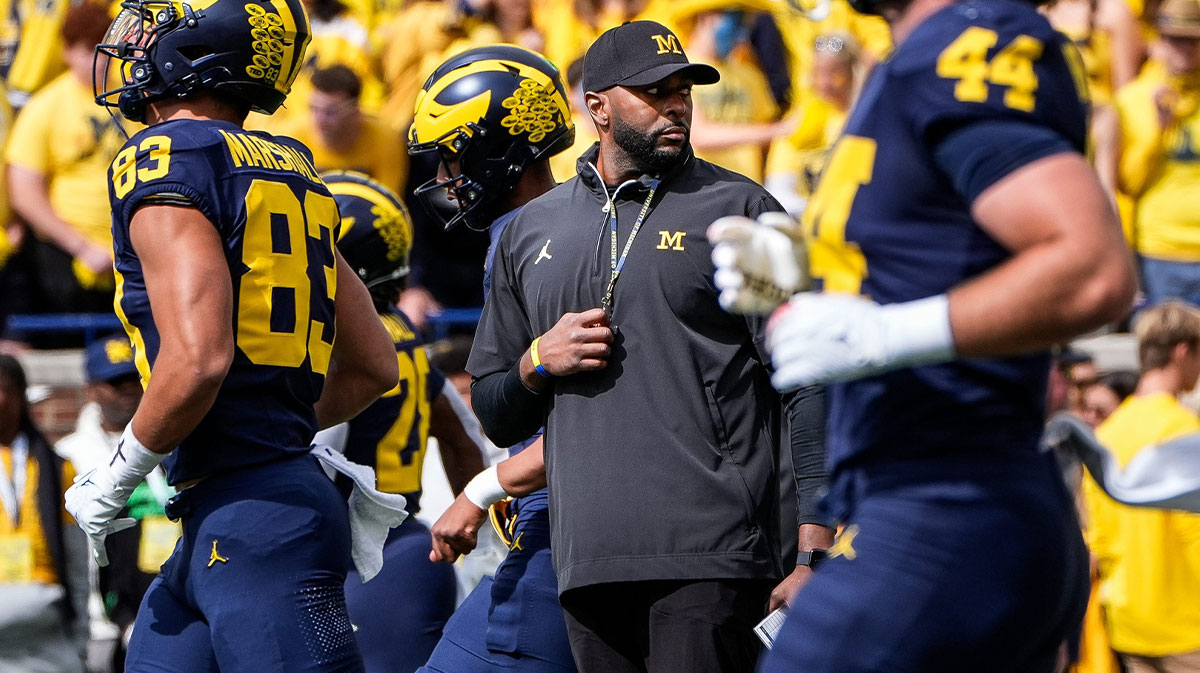 Michigan head coach Sherrone Moore, center, watches warm up before the Texas game at Michigan Stadium