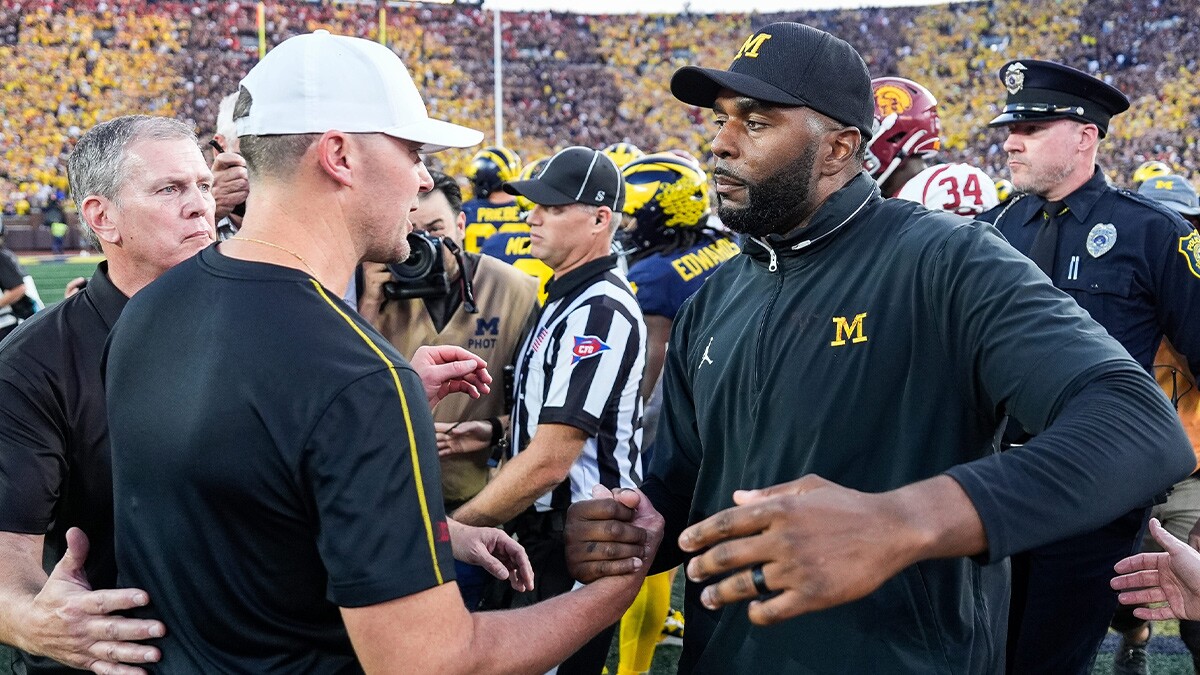 Michigan head coach Sherrone Moore shakes hands with USC head coach Lincoln Riley after 27-24 win at Michigan Stadium