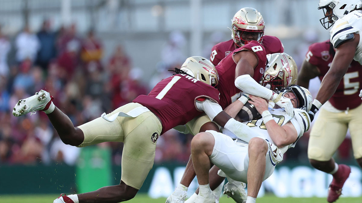 Georgia Tech quarterback Haynes King is tackled by Florida State defensive back Shyheim Brown and defensive lineman Makius Scott at Aviva Stadium.
