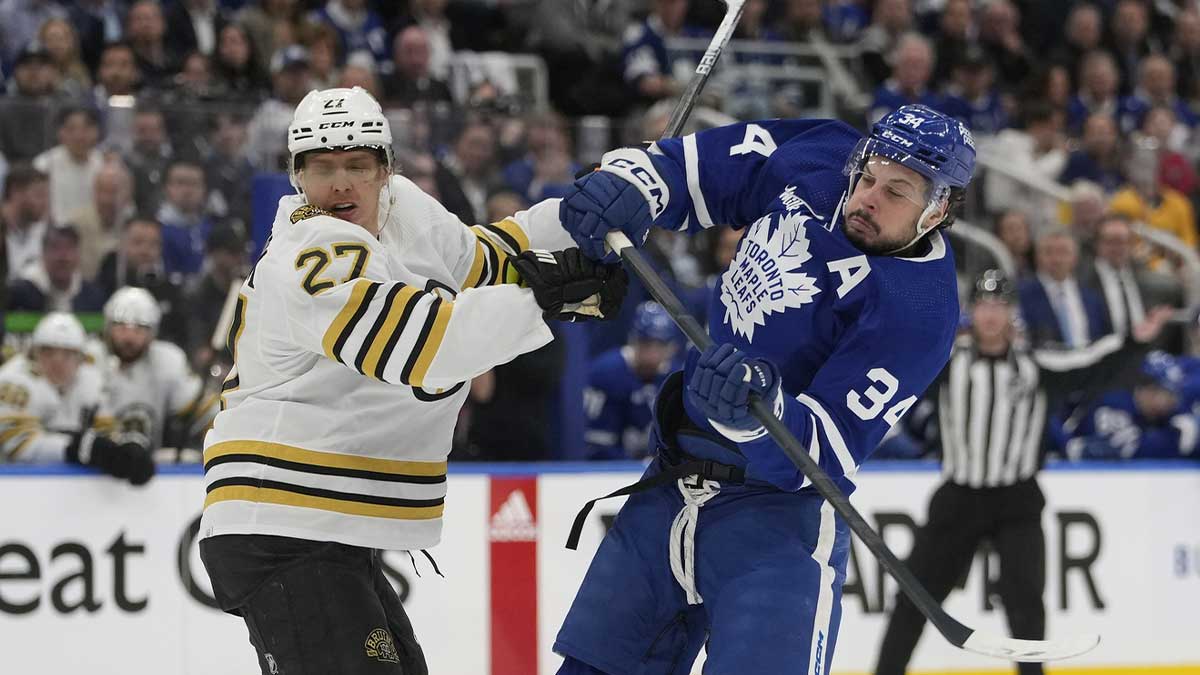 Maple Leafs forward Auston Matthews (34) and Boston Bruins defenseman Hampus Lindholm (27) battle for position during the first period of game three of the first round of the 2024 Stanley Cup Playoffs at Scotiabank Arena.