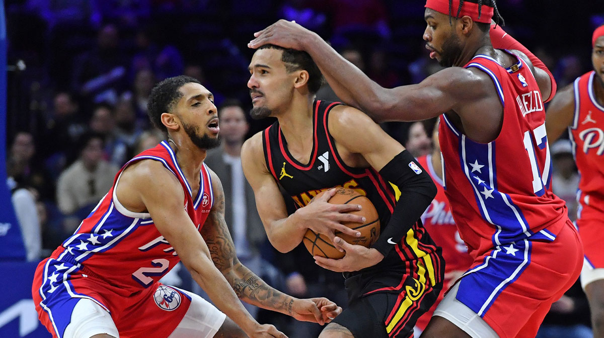 Atlanta Hawks guard Trae Young (11) is defended by Philadelphia 76ers guard Cameron Payne (22) and guard Buddy Hield (17) during the fourth quarter at Wells Fargo Center