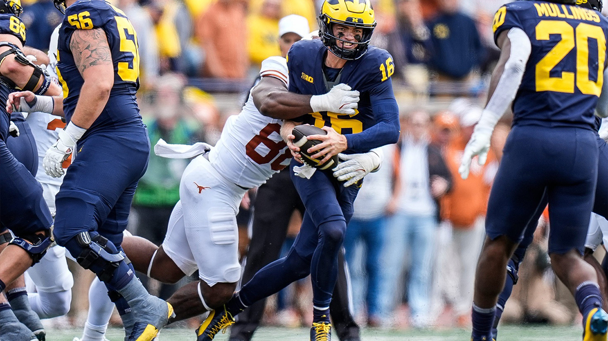 Michigan football quarterback Davis Warren (16) is sacked by Texas linebacker Barryn Sorrell (88).