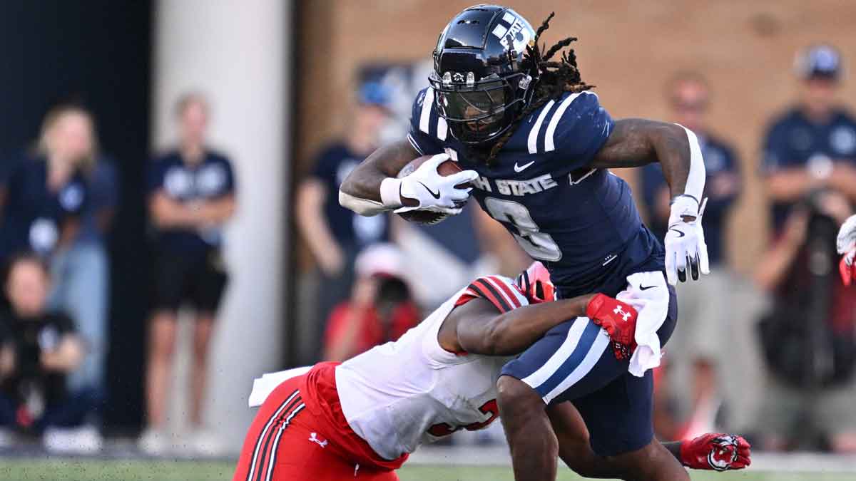 Utah State Aggies running back Rahsul Faison (3) is brought down by Utah Utes linebacker Levani Damuni (3) after a short gain in the second half at Merlin Olsen Field at Maverik Stadium.
