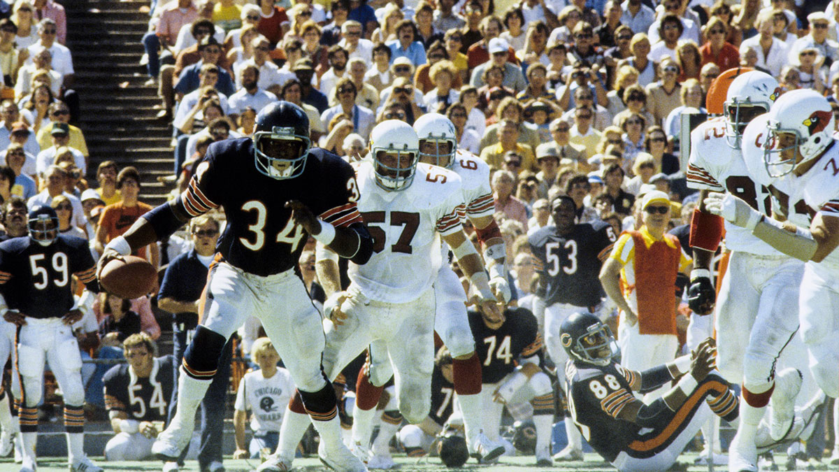 Chicago Bears running back Walter Payton (34) carries the ball under pressure from St. Louis Cardinals linebacker Mark Arneson (57) at Soldier Field.