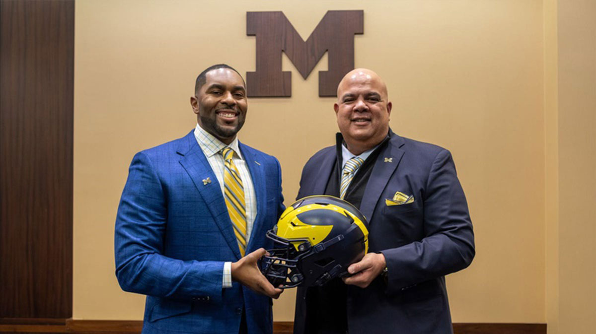 Sherrone Moore, head coach of the University of Michigan, stands next to Warde Manuel, Michigan s Director of Athletics, during a press conference inside the Junge Family Champions Center