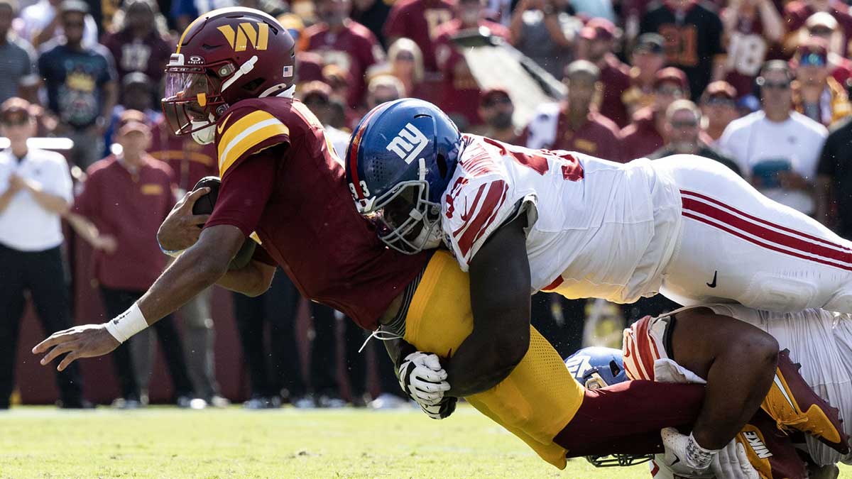 New York Giants defensive tackle Rakeem Nunez-Roches (93) tackles Washington Commanders quarterback Jayden Daniels (5) in the second half at Commanders Field.