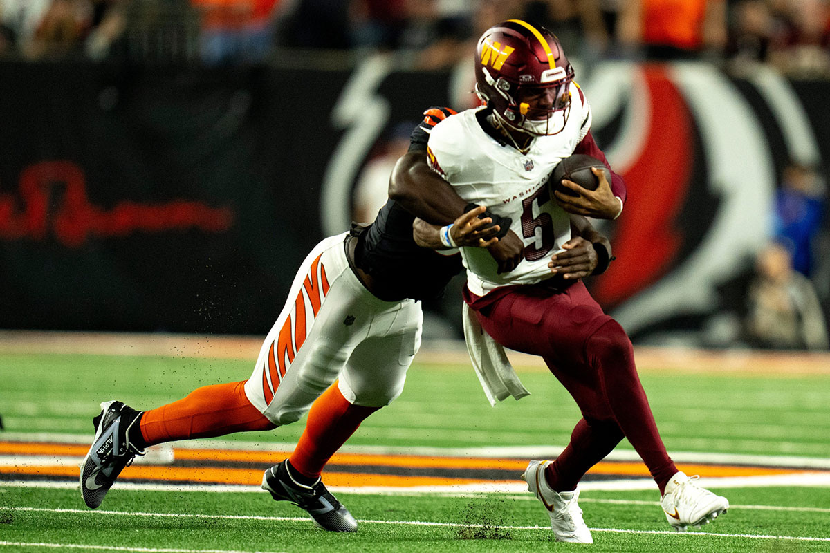 Cincinnati Bengals defensive end Cedric Johnson (52) tackles Washington Commanders quarterback Jayden Daniels (5) in the fourth quarter of the NFL game at Paycor Stadium in Cincinnati on Monday, Sept. 23, 2024.
