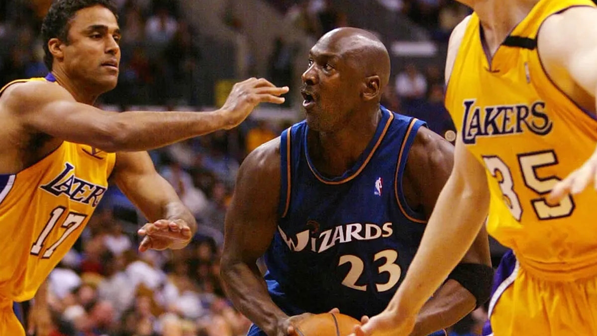 Washington Wizards guard Michael Jordan (23) drives to the basket between Los Angeles Lakers forward Rick Fox (44) and Mark Madsen (35) during the third quarter of the Wizards 108 - 94 loss to the Lakers at Staples Center. Jordan scored 23 points in the game.