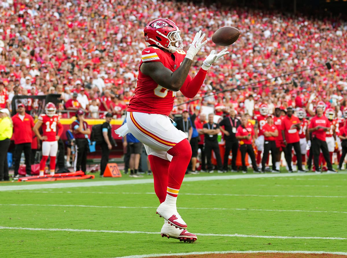 Kansas City Chiefs offensive tackle Wanya Morris (64) catches a touchdown pass during the second half against the Cincinnati Bengals at GEHA Field at Arrowhead Stadium. 