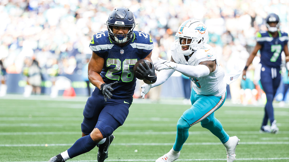 Seattle Seahawks running back Zach Charbonnet (26) breaks a tackle attempt by Miami Dolphins linebacker Anthony Walker Jr. (6) to rush for a touchdown during the fourth quarter at Lumen Field