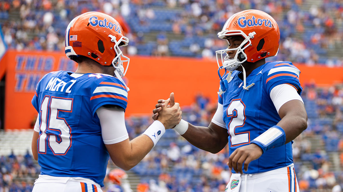 Florida Gators quarterback Graham Mertz (15) and Florida Gators quarterback DJ Lagway (2) embrace before a game against the Texas A&M Aggies at Ben Hill Griffin Stadium.
