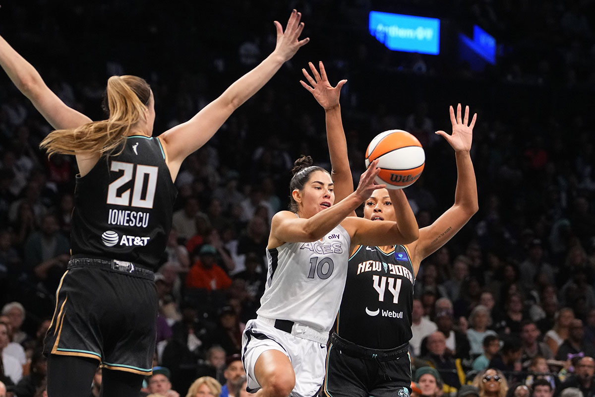 Las Vegas Aces guard Kelsey Plum (10) passes the ball against New York Liberty guard Sabrina Ionescu (20) and New York Liberty forward Betnijah Laney-Hamilton (44) during Game 1 of the 2024 WNBA Semifinals at Barclays Center. 