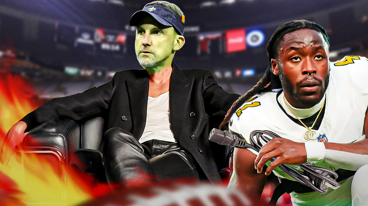 Dennis Allen sitting in a Saints-branded hot seat with Alvin Kamara holding the plug.