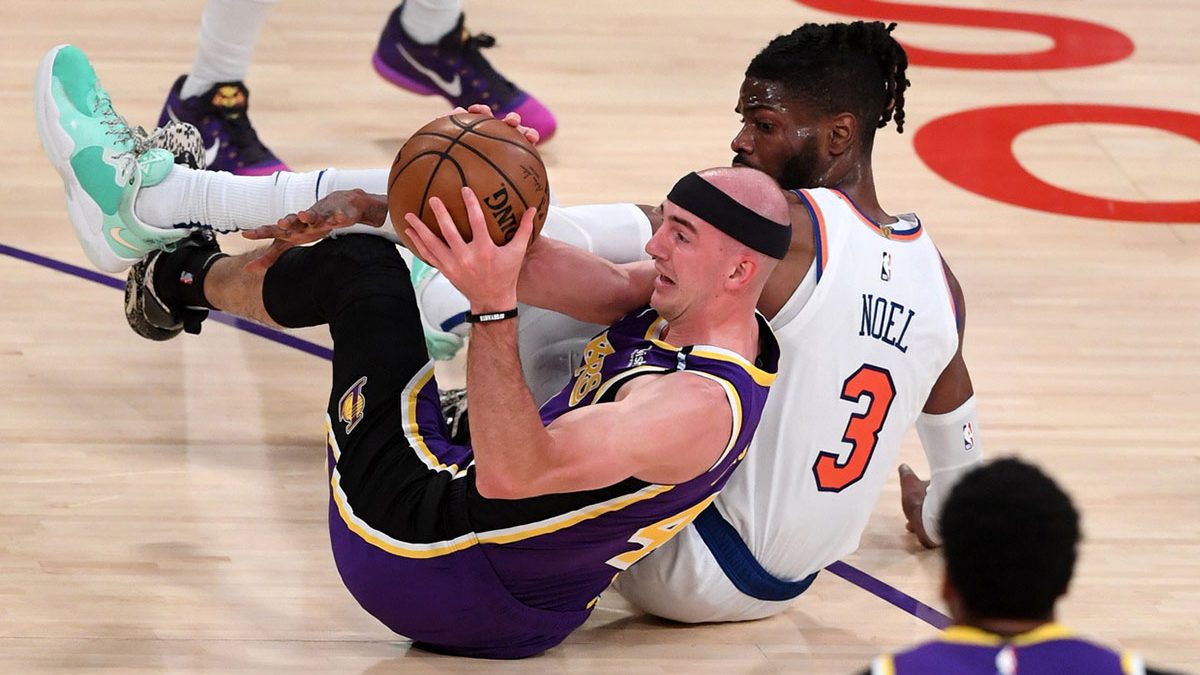 Los Angeles Lakers guard Alex Caruso (4) and New York Knicks center Nerlens Noel (3) scramble for a loose ball in the first quarter of the game at Staples Center.