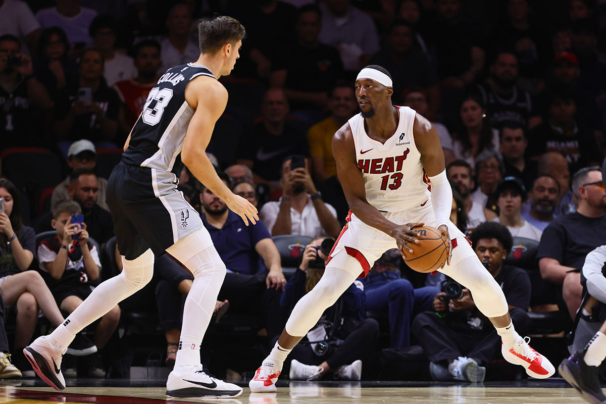 Miami Heat center Bam Adebayo (13) controls the basketball against San Antonio Spurs forward Zach Collins (23) during the second quarter at Kaseya Center.