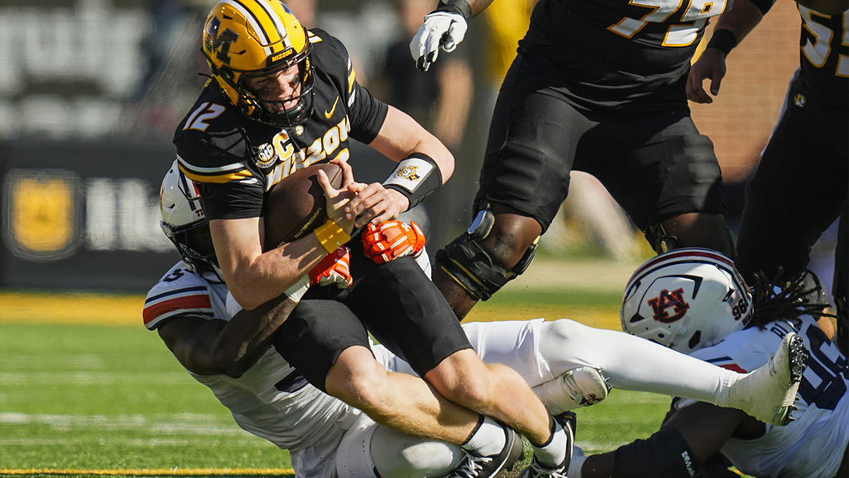 Missouri Tigers quarterback Brady Cook (12) is tackled by Auburn Tigers nose tackle Jalen McLeod (35) during the first half at Faurot Field at Memorial Stadium.