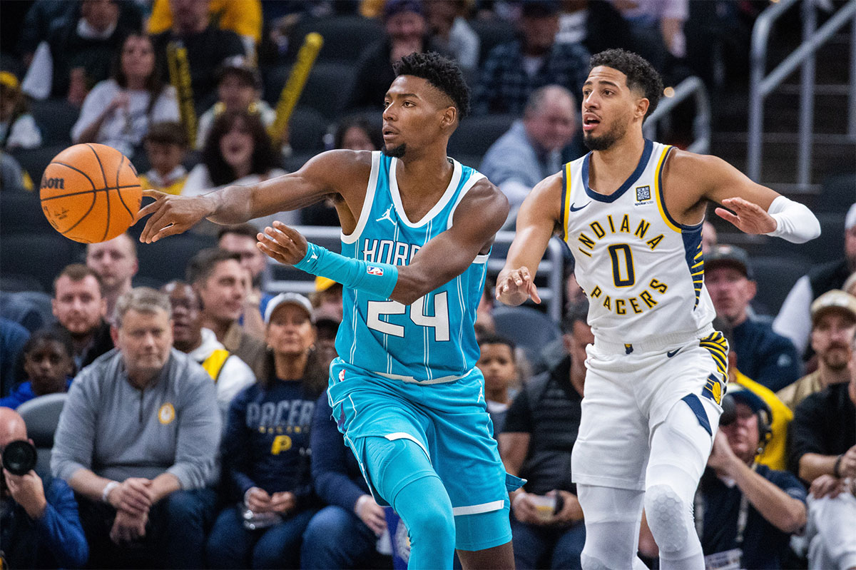 Charlotte Hornets forward Brandon Miller (24) passes the ball while Indiana Pacers guard Tyrese Haliburton (0) defends in the first half at Gainbridge Fieldhouse.