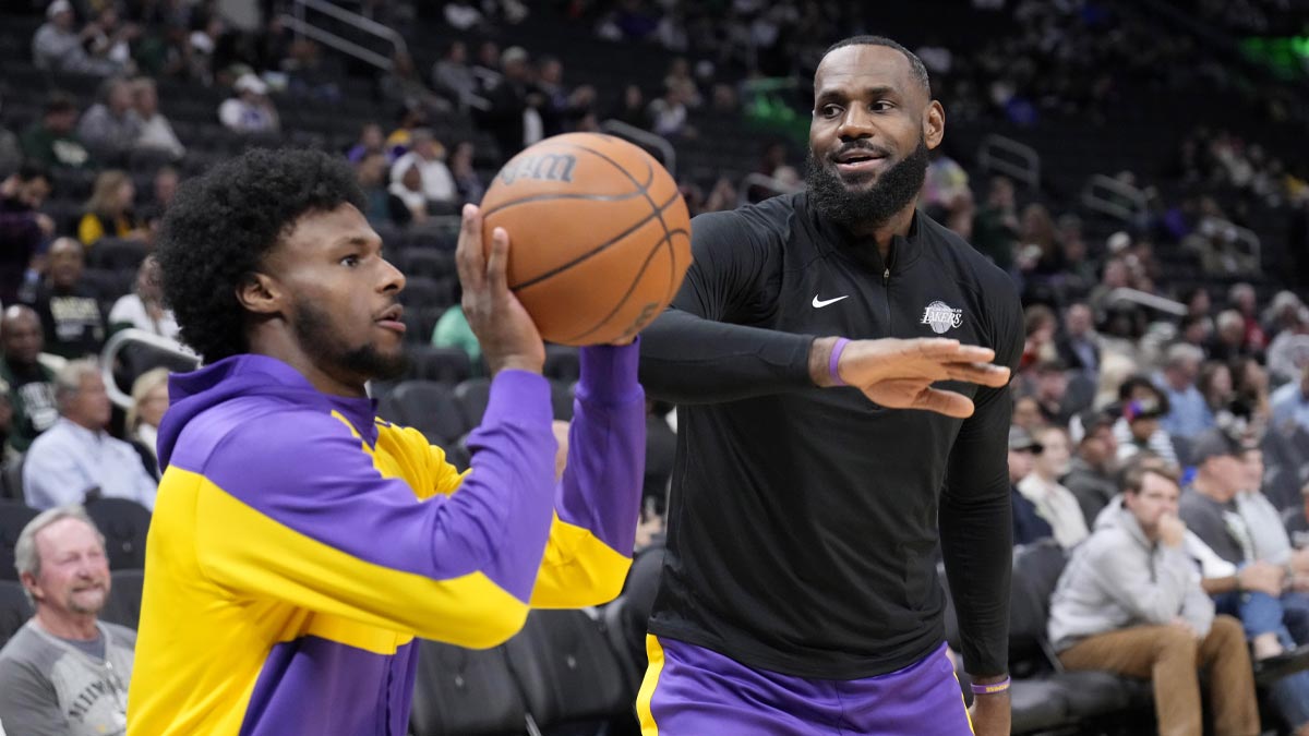 Los Angeles Lakers forward LeBron James (23) goofs around with his son guard Bronny James (9) during warm ups before their game against the Milwaukee Bucks at Fiserv Forum.