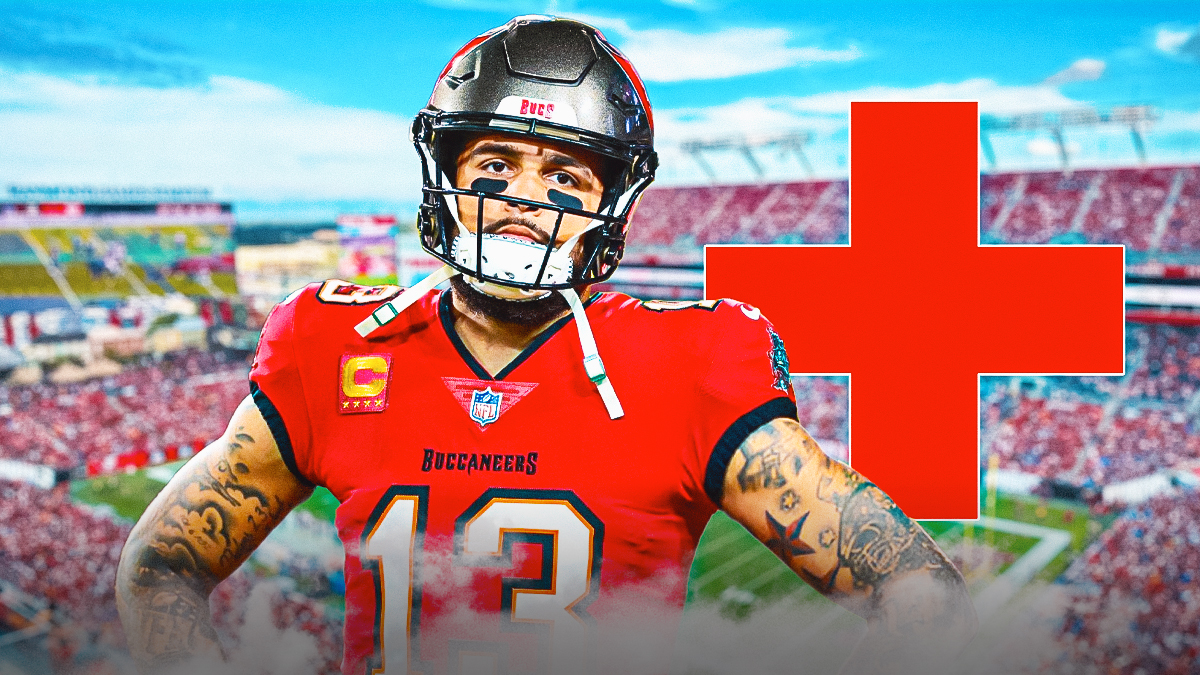 Tampa Bay Buccaneers wide receiver Mike Evans in pain in center, health/injury sign next to him, Raymond James Stadium (home stadium of the Tampa Bay Buccaneers) in background