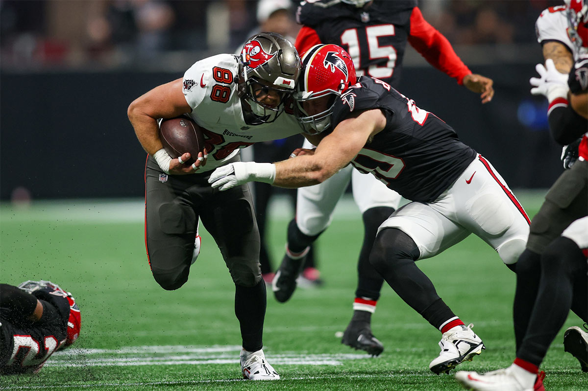 Tampa Bay Buccaneers tight end Cade Otton (88) is tackled by Atlanta Falcons linebacker JD Bertrand (40) in the first quarter at Mercedes-Benz Stadium.