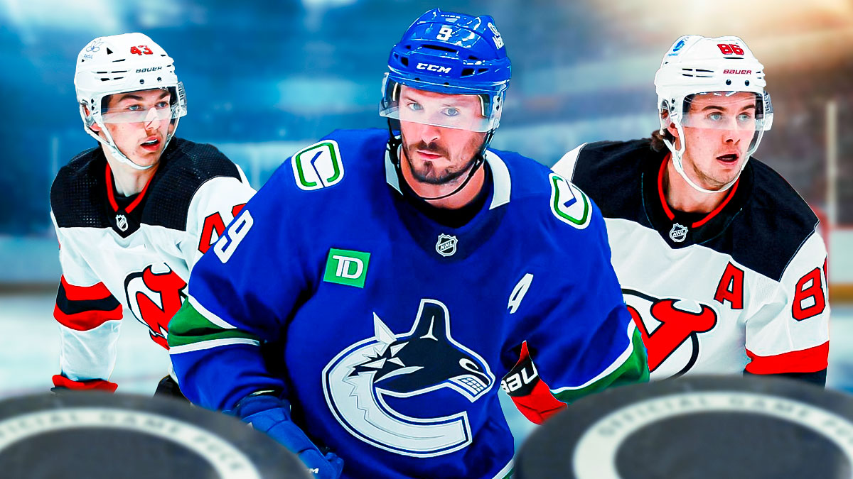 JT Miller in middle looking stern, Jack Hughes and Luke Hughes on either side looking happy, hockey rink in background