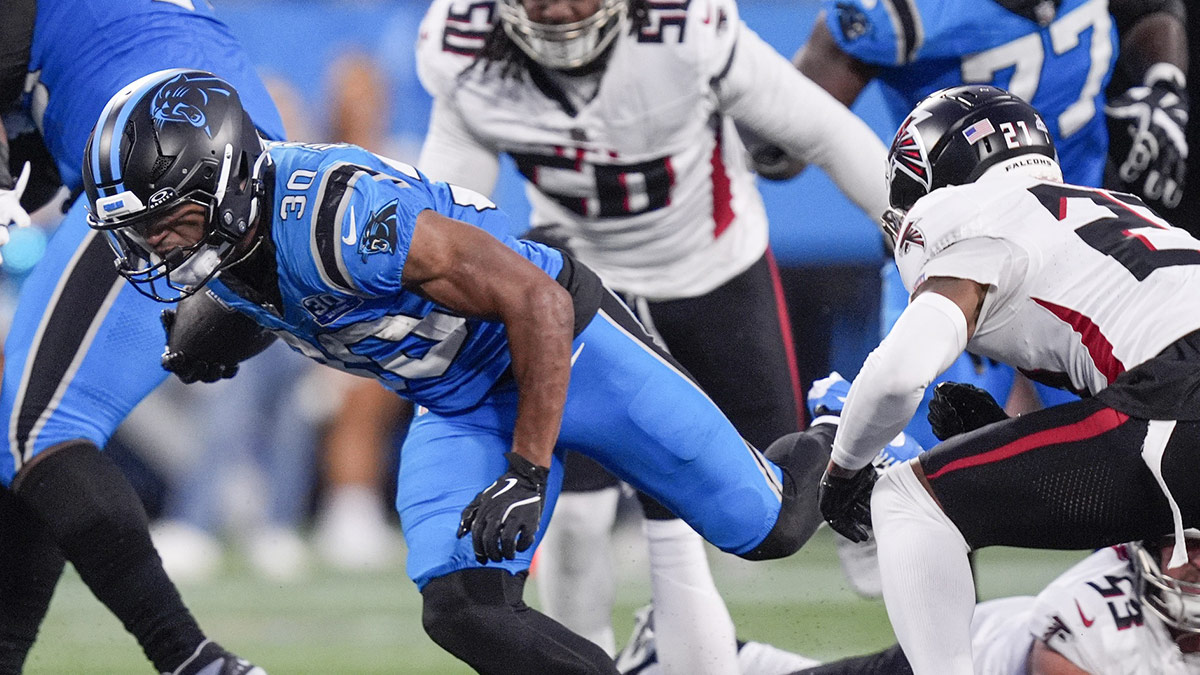 Carolina Panthers running back Chuba Hubbard (30) is tripped up by Atlanta Falcons linebacker Kaden Elliss (55) during the second half at Bank of America Stadium.