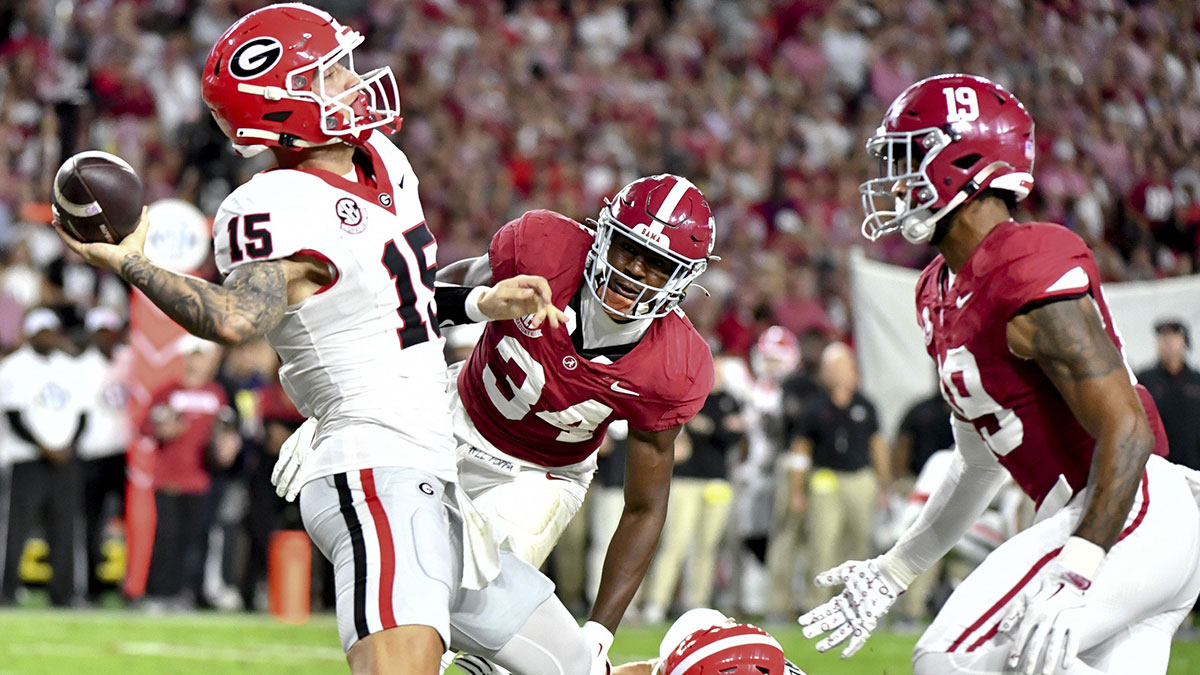 Georgia Bulldogs quarterback Carson Beck (15) is penalized for grounding as he is pressured in the end zone by Alabama Crimson Tide linebacker Que Robinson (34) and linebacker Keanu Koht (19) resulting in a safety at Bryant-Denny Stadium.