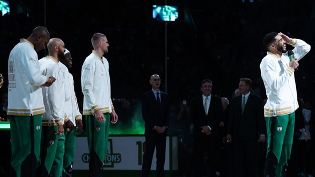 Boston Celtics forward Jayson Tatum (0) talks to the crowd after presented with a championship ring during the opening night banner raising ceremony before the start of the game against the New York Knicks at TD Garden