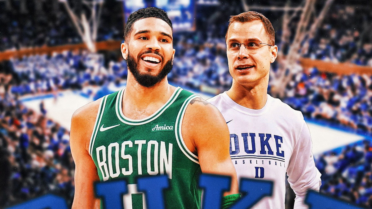 Jayson Tatum and Jon Scheyer smiling/laughing at each other on a Duke background