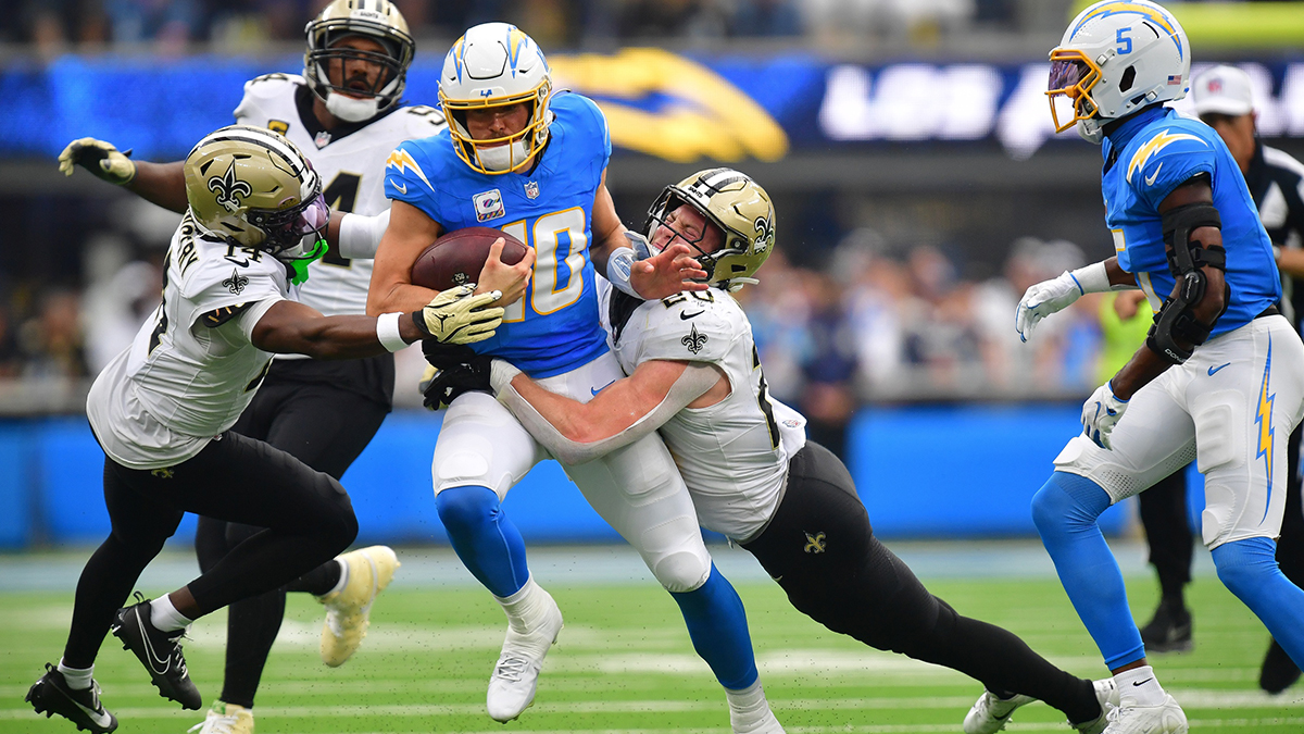 New Orleans Saints linebacker Pete Werner (20) and cornerback Kool-Aid McKinstry (14) stop Los Angeles Chargers quarterback Justin Herbert (10) during the first half at SoFi Stadium
