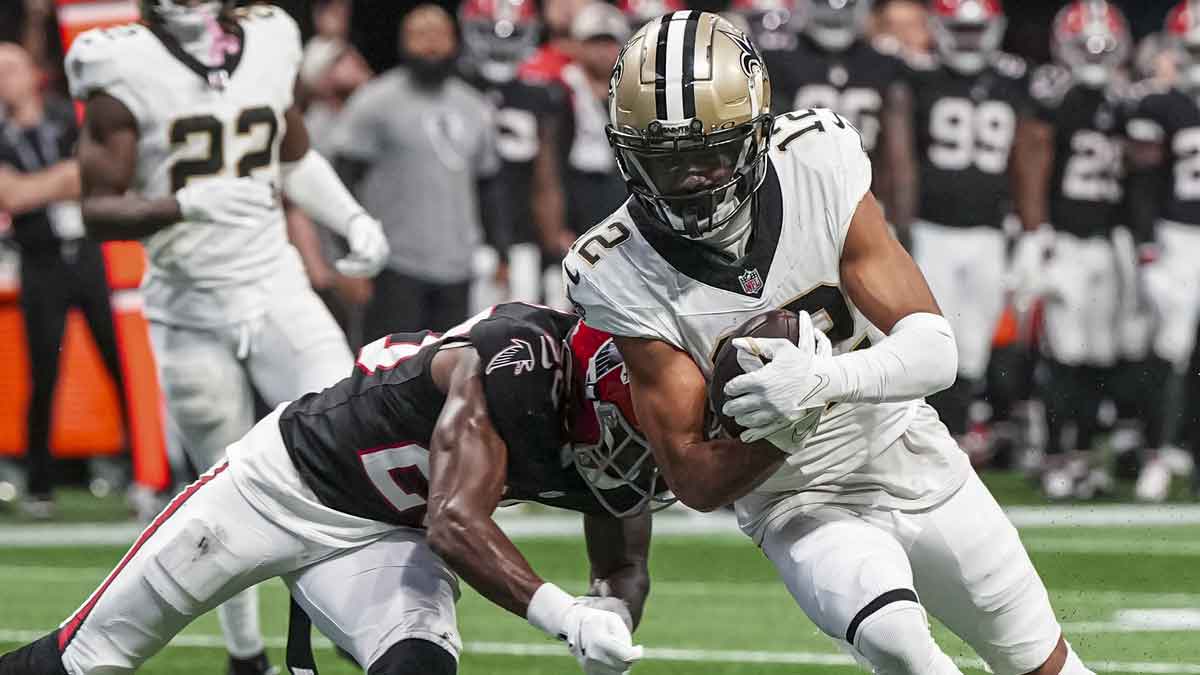 Sep 29, 2024; Atlanta, Georgia, USA; New Orleans Saints wide receiver Chris Olave (12) is tackled by Atlanta Falcons cornerback Dee Alford (20) after catching a pass against the Atlanta Falcons during the fourth quarter at Mercedes-Benz Stadium.