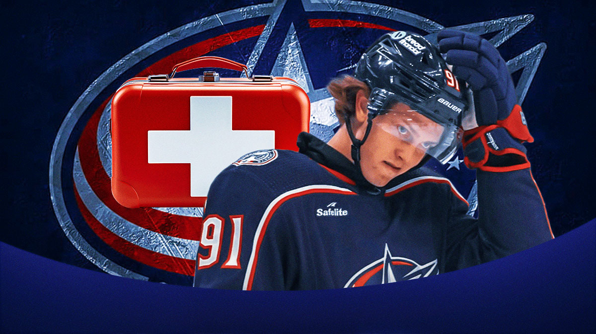 Kent Johnson looking serious, first aid kit, Columbus Blue Jackets logo, hockey rink in background