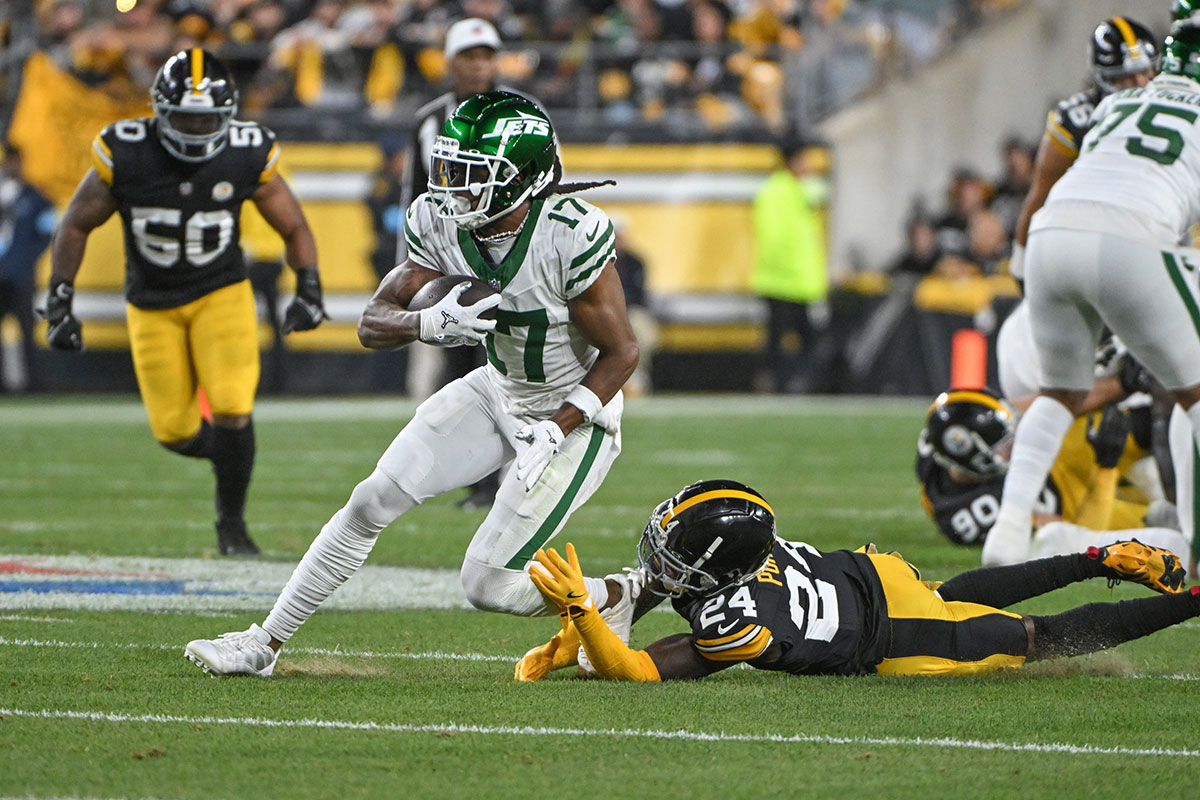 Oct 20, 2024; Pittsburgh, Pennsylvania, USA; NNew York Jets wide receiver Davante Adams (17) eludes Pittsburgh Steelers cornerback Joey Porter Jr. (24) on a pass during the first quarter at Acrisure Stadium.