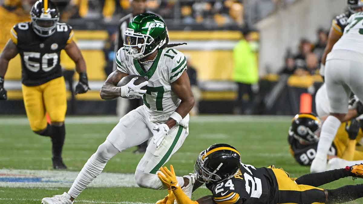 New York Jets wide receiver Davante Adams (17) eludes Pittsburgh Steelers cornerback Joey Porter Jr. (24) on a pass during the first quarter at Acrisure Stadium.