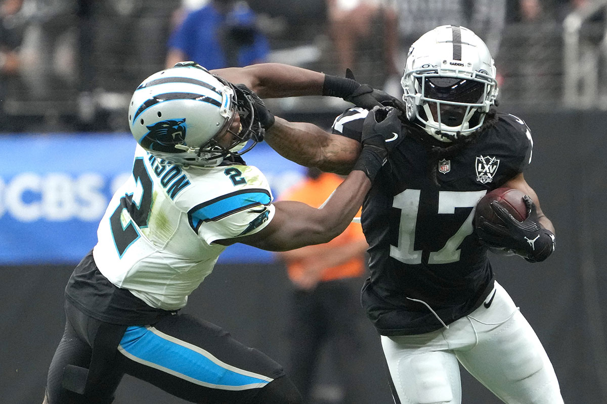 Las Vegas Raiders wide receiver Davante Adams (17) carries the ball against Carolina Panthers cornerback Michael Jackson (2) in the first half at Allegiant Stadium.
