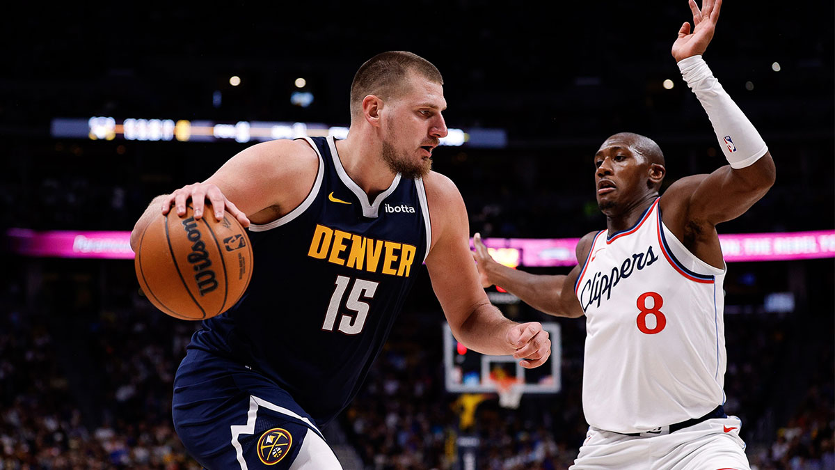 Denver Nuggets center Nikola Jokic (15) controls the ball as Los Angeles Clippers guard Kris Dunn (8) guards in the fourth quarter at Ball Arena.