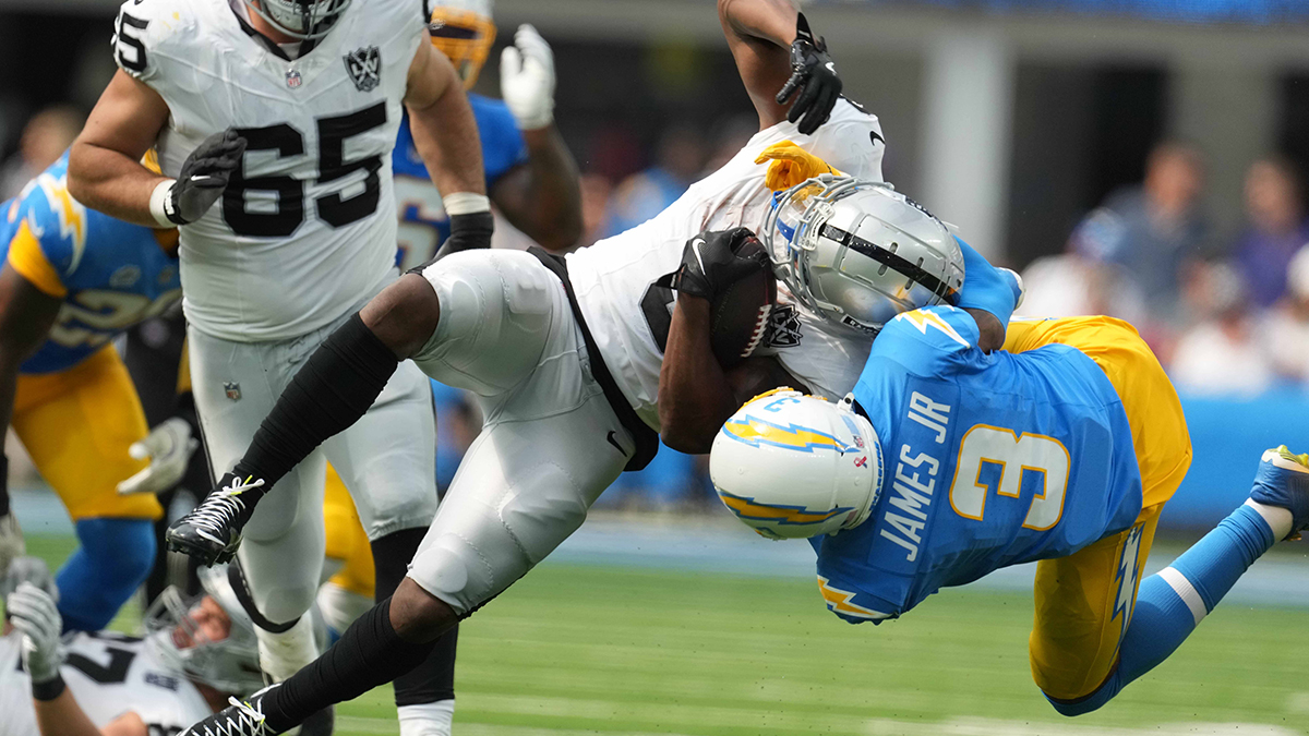 Sep 8, 2024; Inglewood, California, USA; Las Vegas Raiders running back Zamir White (left) is tackled by Los Angeles Chargers safety Derwin James Jr (3) in the second half at SoFi Stadium.