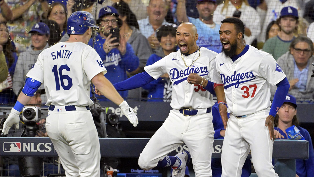 Los Angeles Dodgers catcher Will Smith (16) celebrates with outfielder Mookie Betts (50) and outfielder Teoscar Hernandez (37) after hitting a two run home run in the third inning against the New York Mets during game six of the NLCS for the 2024 MLB playoffs at Dodger Stadium.
