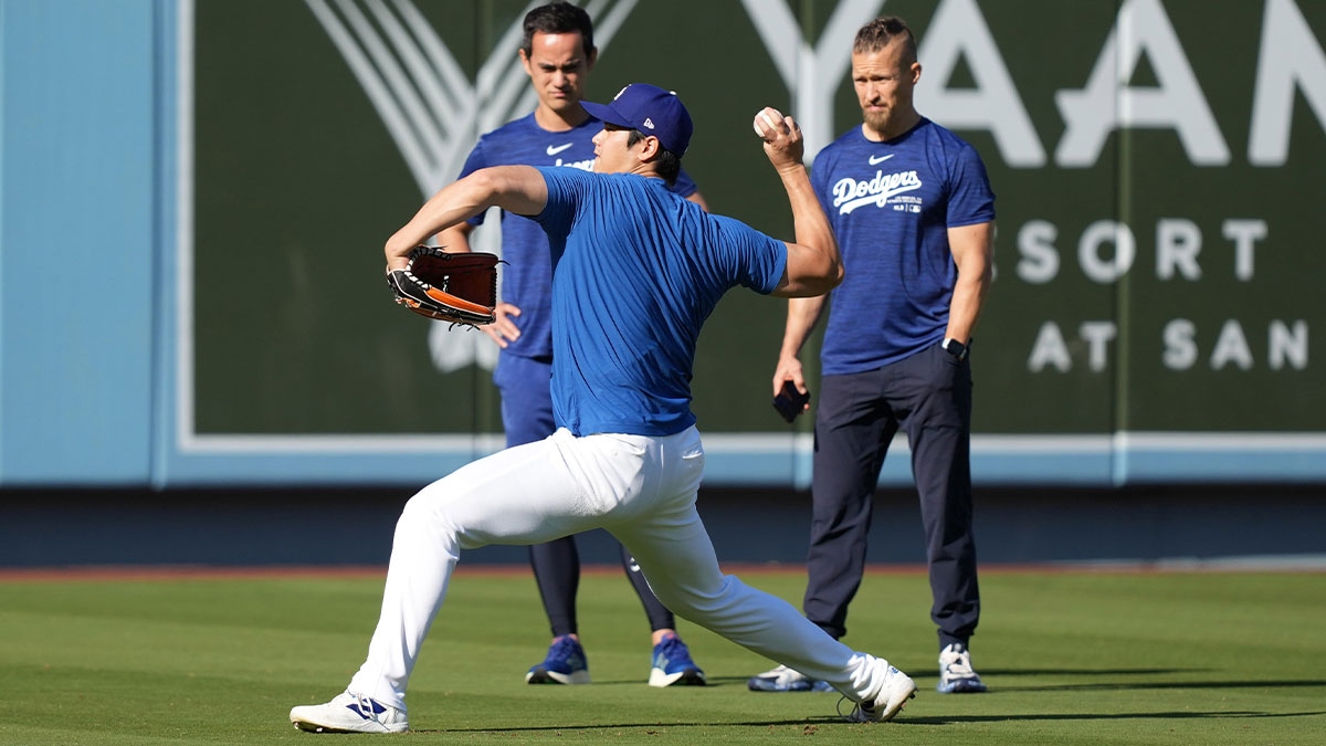 Los Angeles Dodgers designated hitter Shohei Ohtani (right) talks with athletic trainer Thomas Albert and interpreter Will Ireton watch before the game against the San Diego Padres at Dodger Stadium