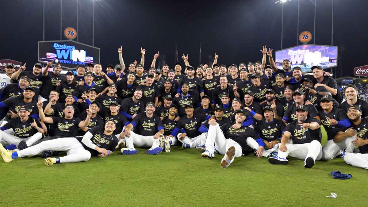 Los Angeles Dodgers players and coaches celebrate on the field after defeating the San Diego Padres in game five of the NLDS for the 2024 MLB Playoffs at Dodger Stadium.