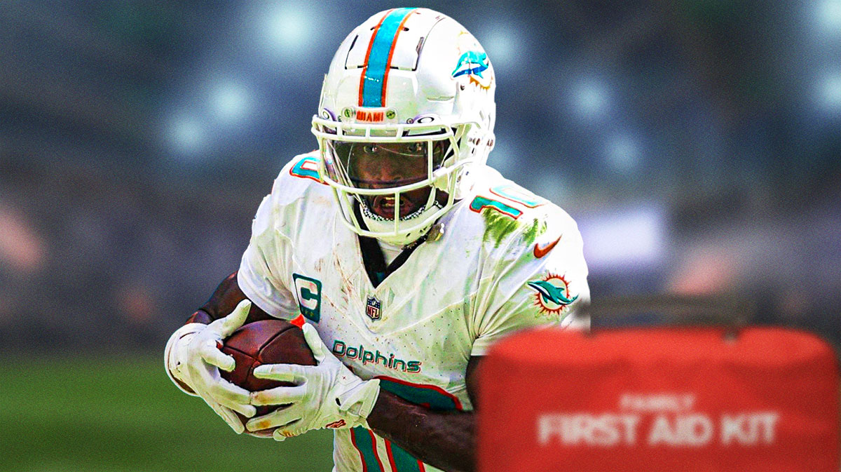 Tyreek Hill in a Miami Dolphins uniform with a red and white first aid symbol as Hill is dealing with injury but returned to practice.