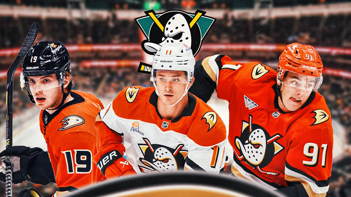 Troy Terry, Trevor Zegras, and Leo Carlsson in front of Ducks logo and ice rink.
