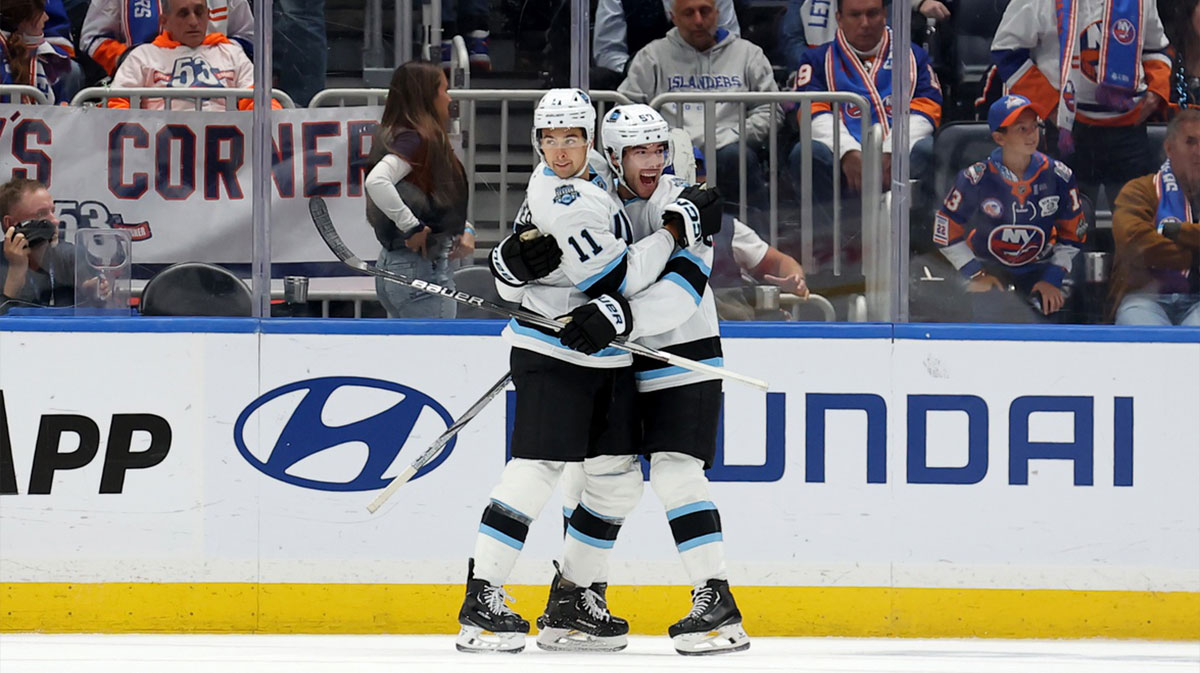 Utah Hockey Club right wing Dylan Guenther (11) celebrates his game winning overtime goal against the New York Islanders with defenseman Sean Durzi (50) at UBS Arena. 